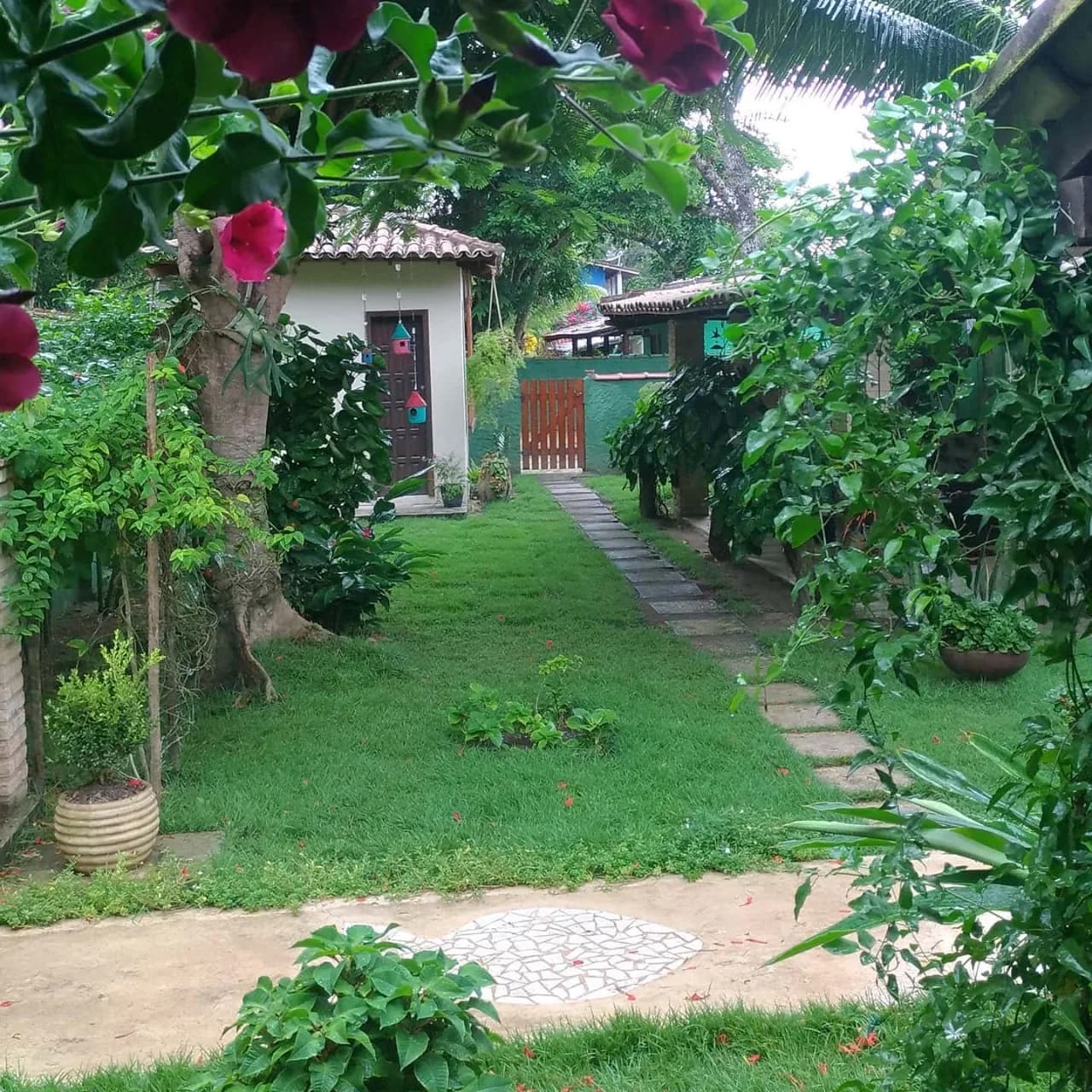 Jardim da Pousada Mayon com flores e caminho de pedras