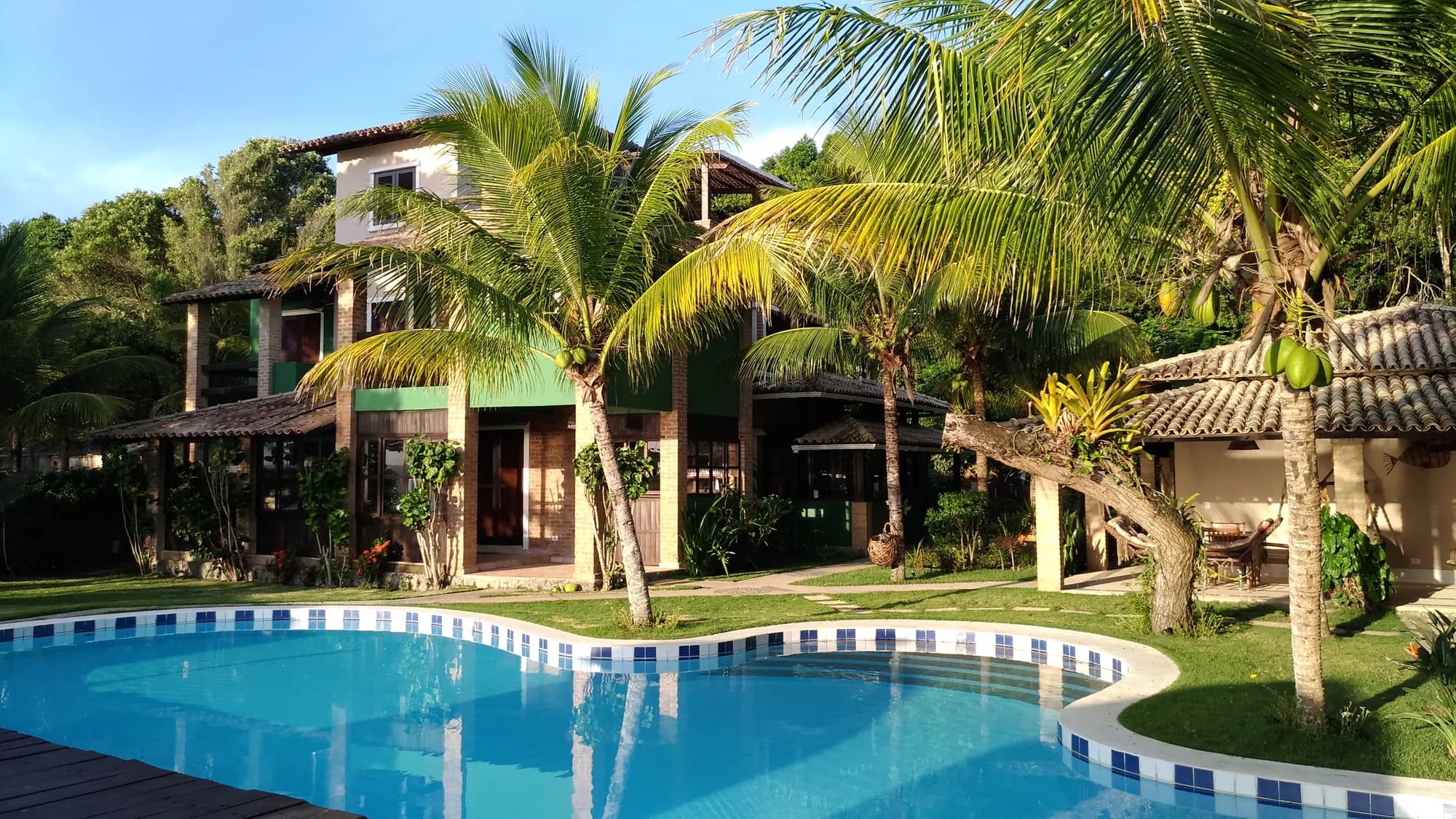 Piscina e casa da Pousada Mayon entre coqueiros