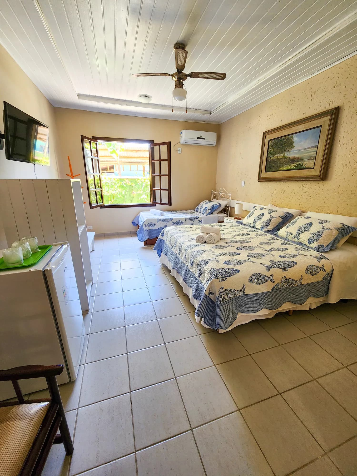 Quarto da Suíte 1 da Pousada Mayon, com camas e janela para o jardim