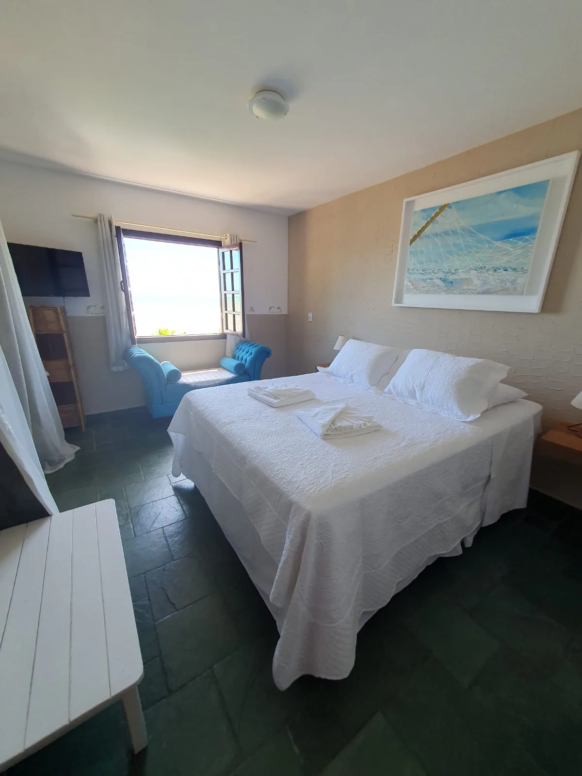 Quarto da Suíte 8 da Pousada Mayon, com cama de casal e janela para o mar