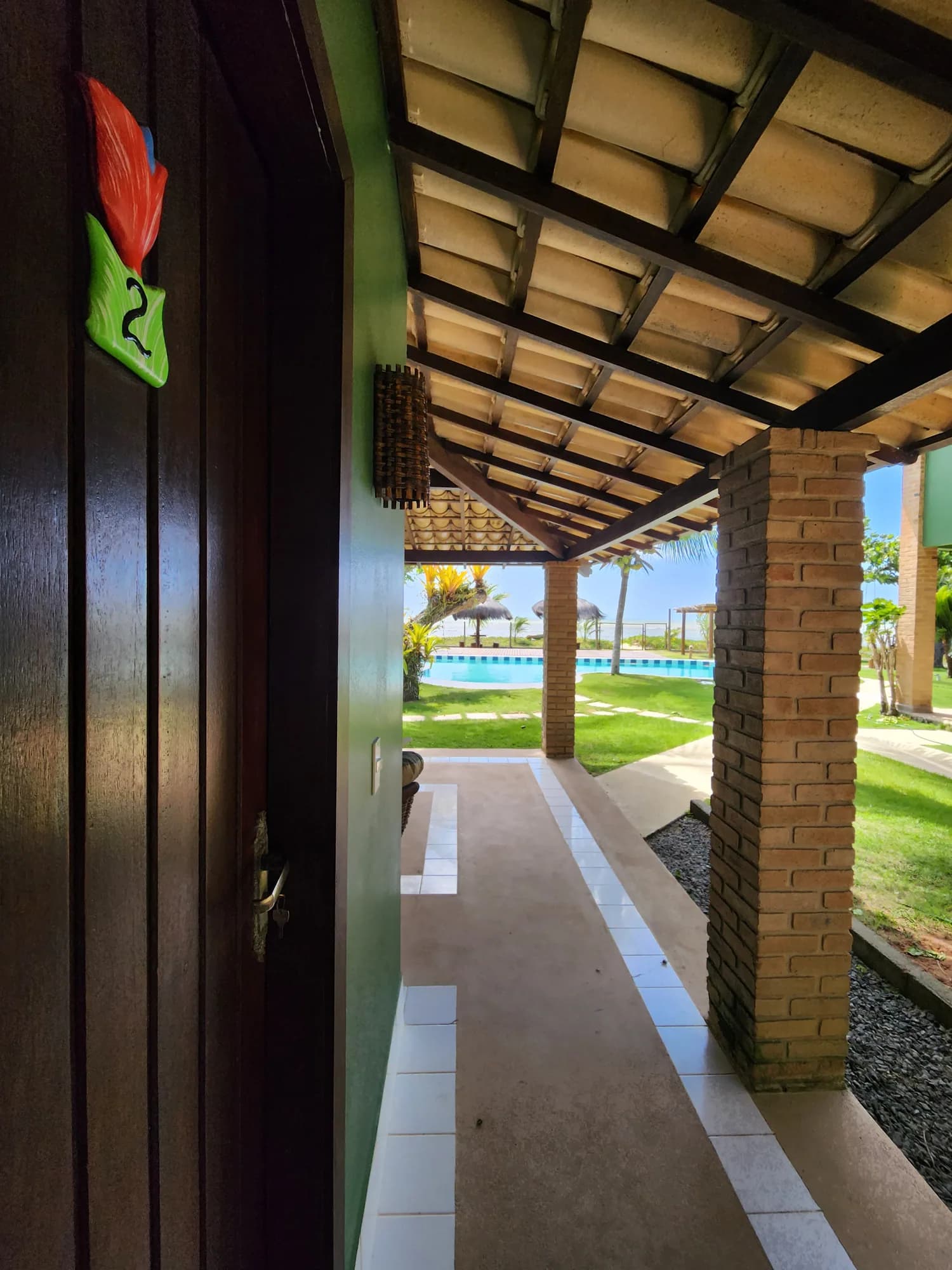 Área externa com a piscina e o mar ao fundo