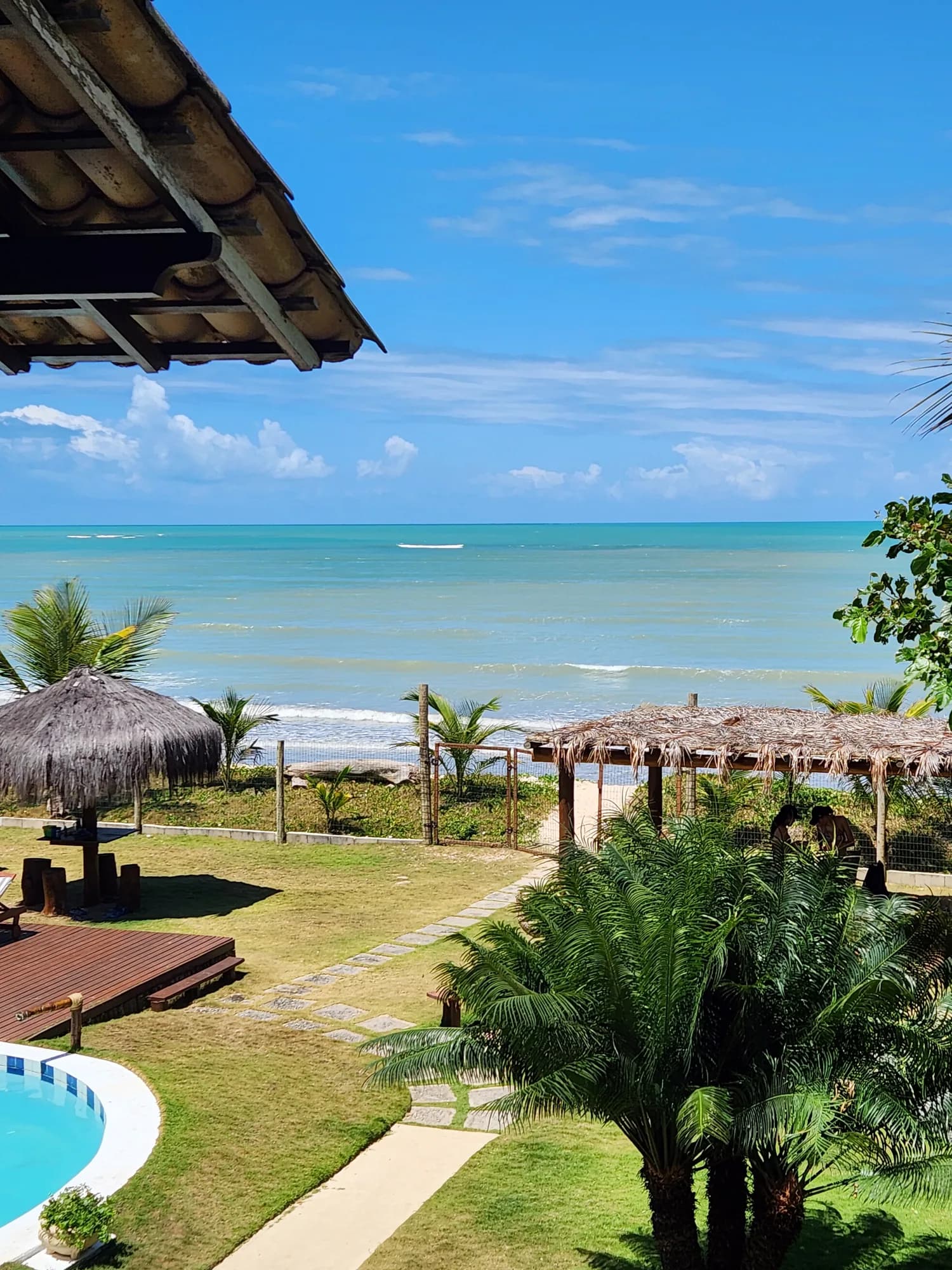 Vista da varanda da Suíte 7 para o mar, a piscina e o quiosque
